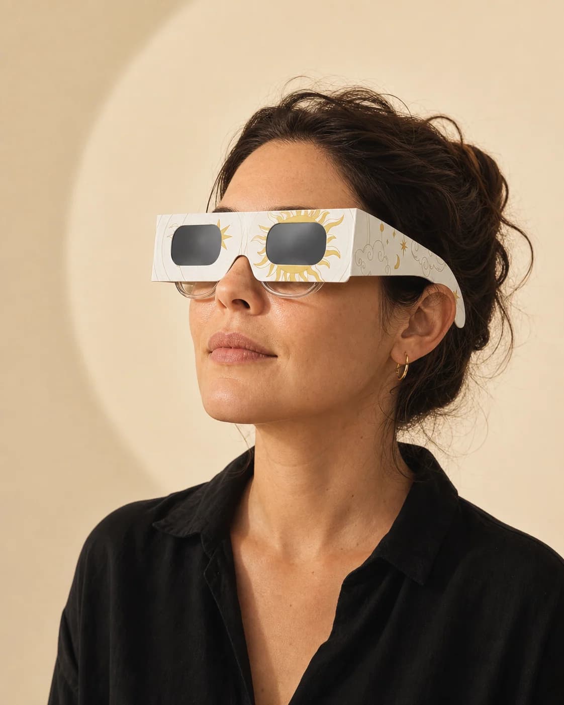 Femme portant les lunettes d’éclipse Aube par-dessus ses lunettes de vue